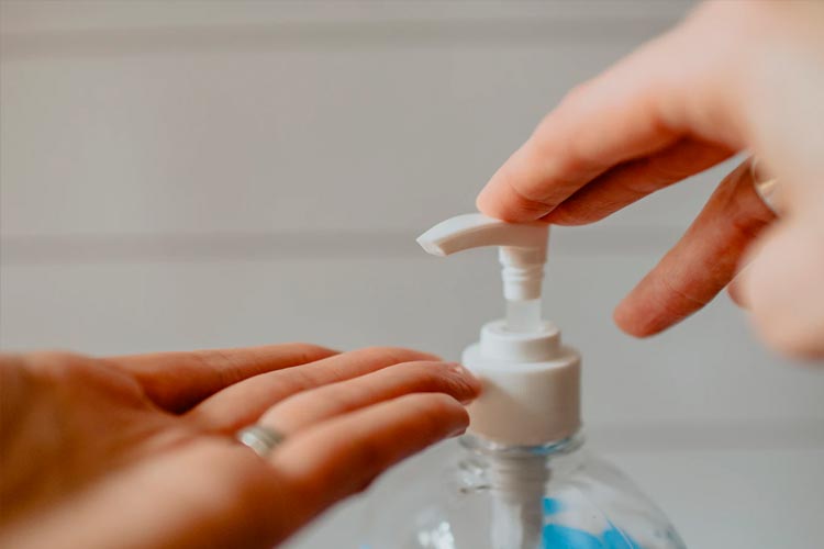 hands using cleaning solution to prevent covid-19